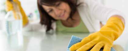 Female housekeeper cleaning the surface of a table with microfiber