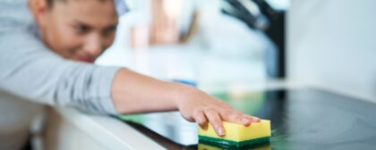 Woman cleaning stovetop in her kitchen